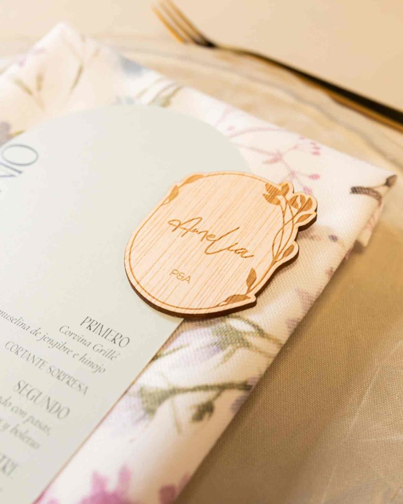 Detalle de mesa de boda decorada con marcasitio silvestre grabado en madera y estilo natural
