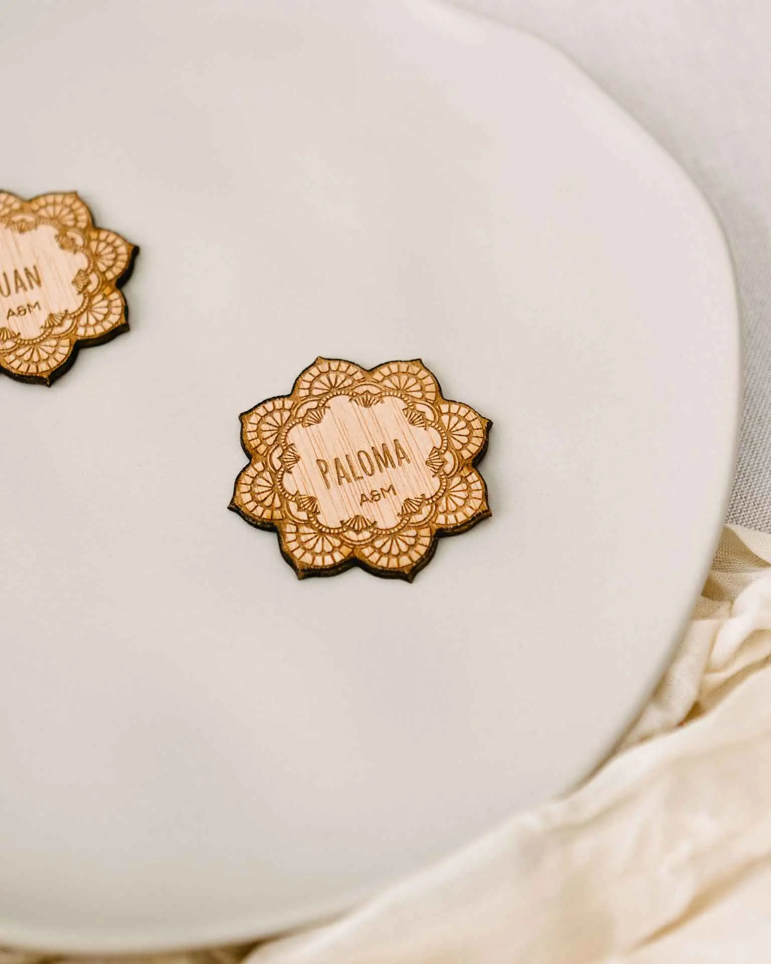 Marcasitios Mandala de madera colocados sobre servilleta como detalle decorativo en mesa de boda