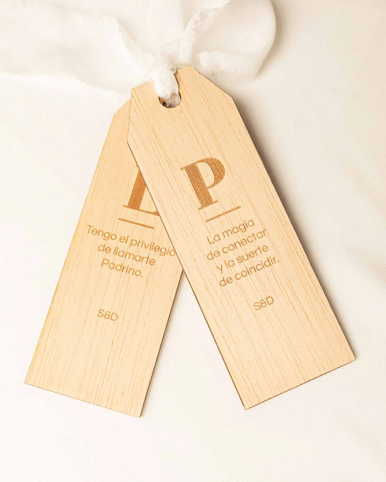Dos marcapáginas personalizados con iniciales grabadas y sedas blancas