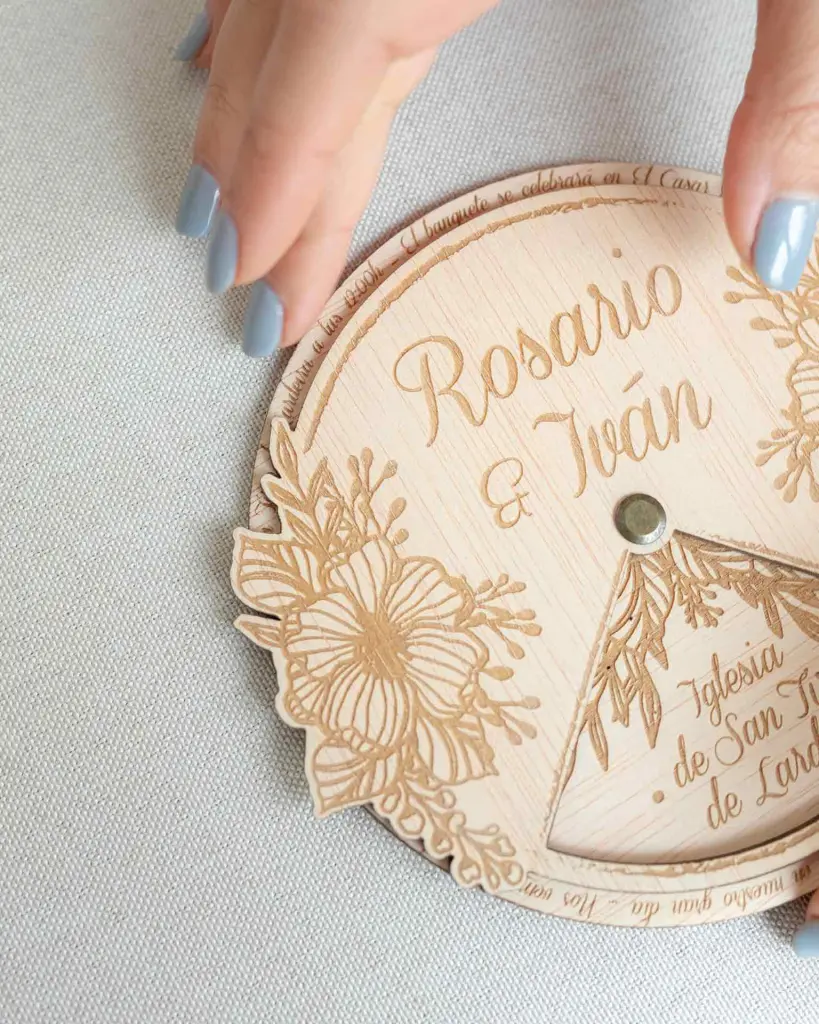 Primer plano del grabado floral en la invitación de boda Jardín, destacando los intrincados detalles sobre la madera natural.