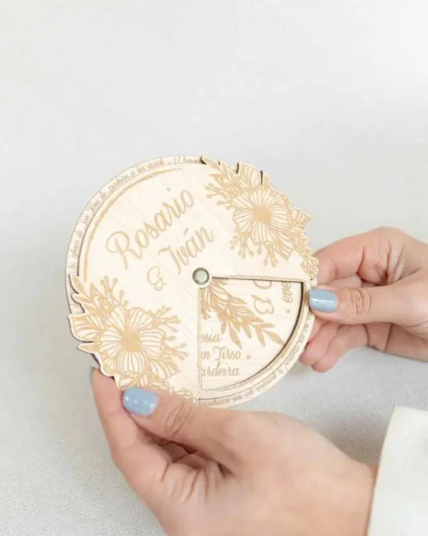 Imagen de la invitación de boda Jardín en mano, mostrando su tamaño y detalle en los grabados florales sobre madera natural.