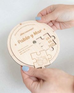 Detalle de la invitación de madera puzzle siendo sostenida