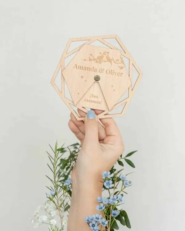 Invitación de boda Nida mostrada en mano, con diseño giratorio y troquelado. Ideal para bodas originales.
