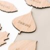 Primer plano del grabado con el nombre del invitado en una hoja de madera del conjunto Forest
