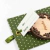 Detalle de una bola de Navidad personalizada en verde, mostrando su grabado y diseu00f1o