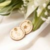 Detalle de dos medallas personalizadas de madera, perfectas para ramo de boda