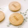 Abrebotellas de madera imantado colocado sobre un plato como detalle en una mesa de boda
