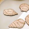 Marcasitios con forma de conchas marinas colocados sobre una servilleta, detalle de boda original