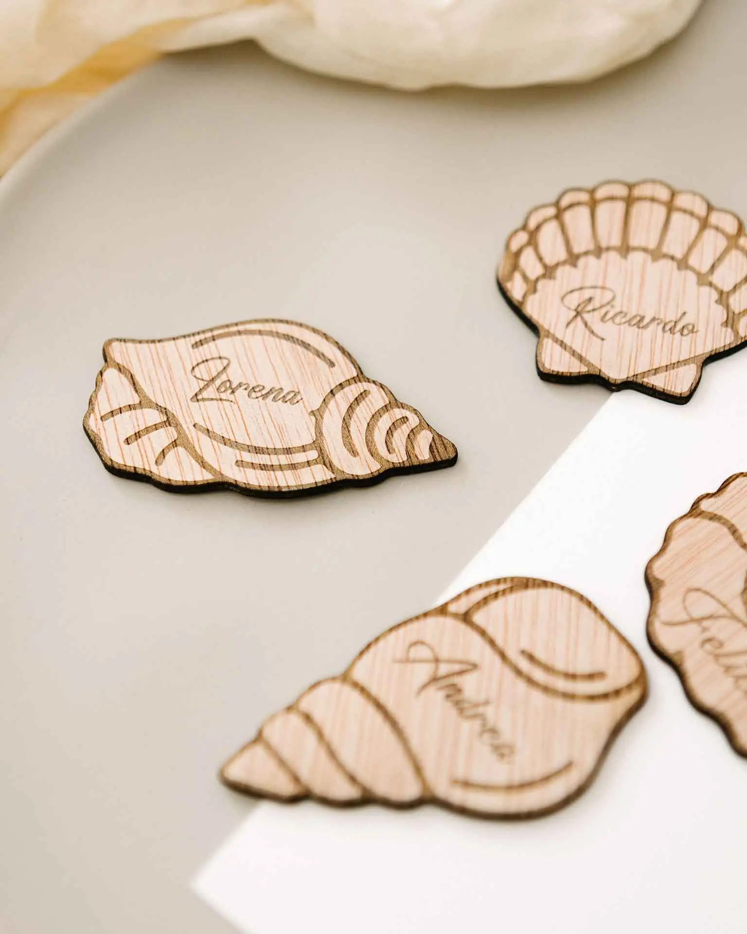 Marcasitios con forma de conchas marinas colocados sobre una servilleta, detalle de boda original