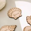 Vista de varios modelos de conchas grabadas en madera como marcasitios personalizados