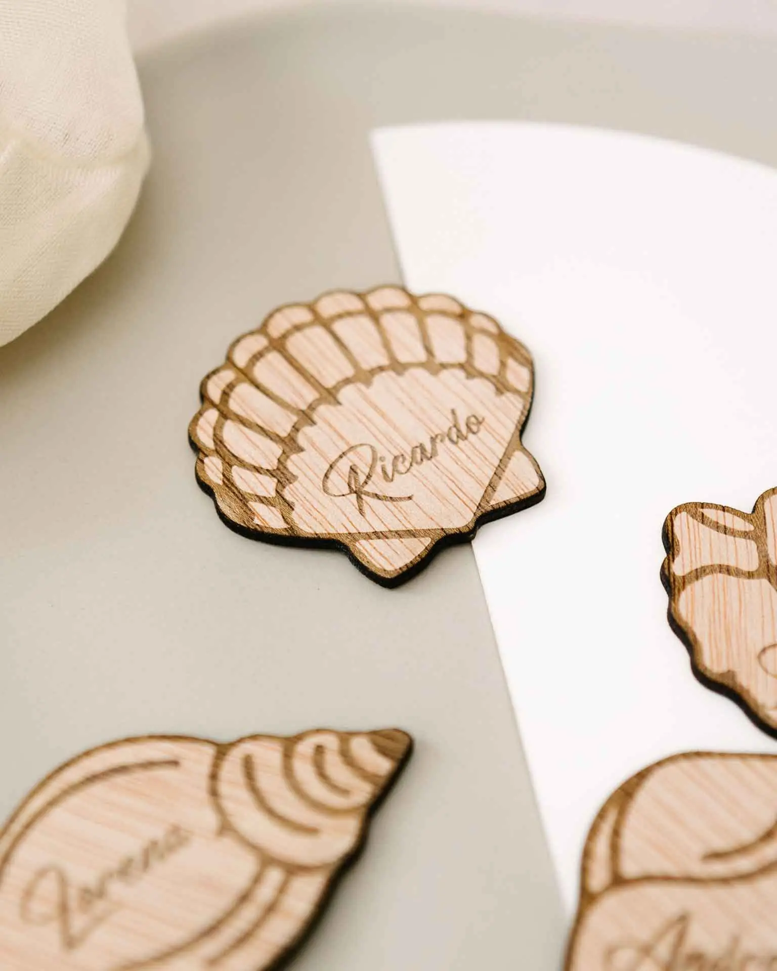 Vista de varios modelos de conchas grabadas en madera como marcasitios personalizados