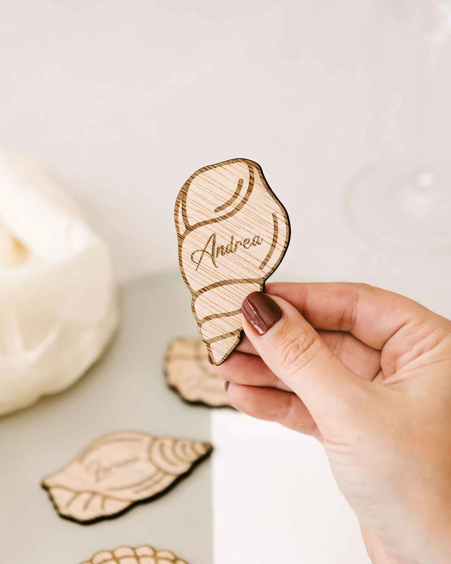 Marcasitios marinos de madera con diferentes formas de conchas, sostenidos en la mano