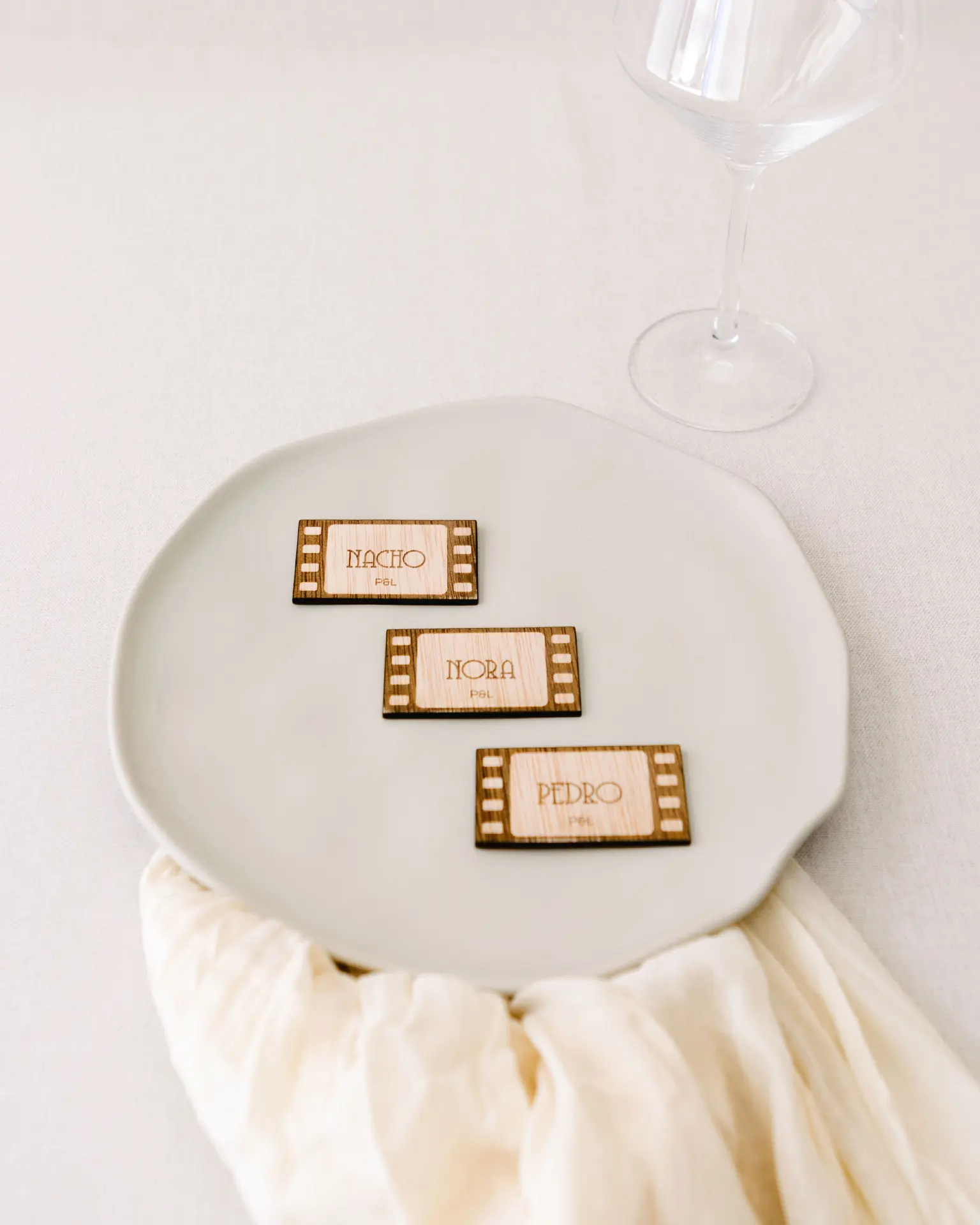 Marcasitio Movie de madera colocado sobre una servilleta como detalle decorativo en mesa de boda
