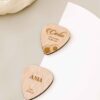 Marcasitios de madera con forma de pu00faa de guitarra grabados con nombres, ideales para bodas con temu00e1tica musical