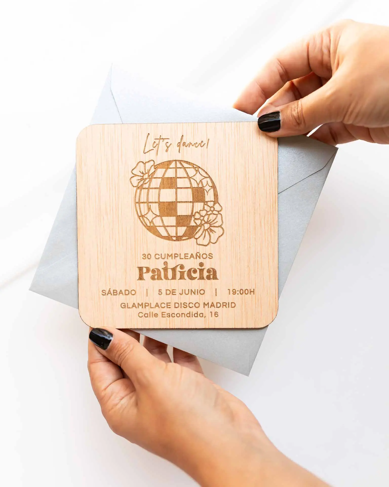 Invitación Disco personalizada con sobre metalizado plateado, vista en mano para mostrar su elegancia.