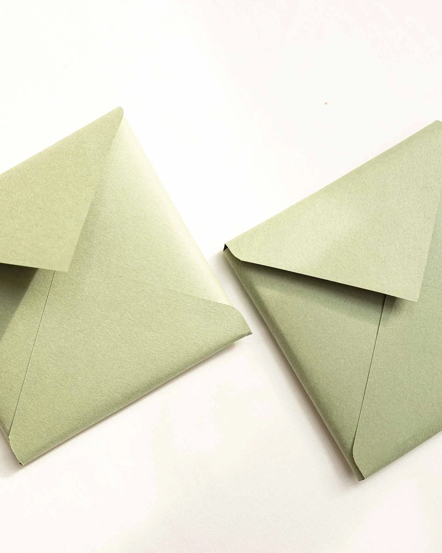 Primer plano de la textura de un sobre a medida en color verde, ideal para bodas con estu00e9tica ru00fastica