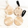 Cuatro modelos de marcasitios bolas Navidad madera personalizados para boda
