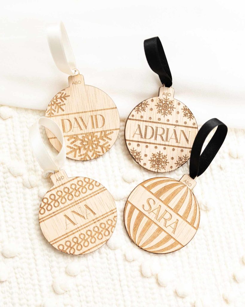 Cuatro modelos de marcasitios bolas Navidad madera personalizados para boda