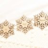 Marcasitios de madera copo de nieve colocados en mesa de boda invernal