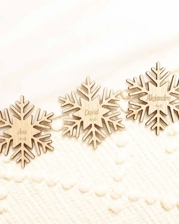 Marcasitios de madera copo de nieve colocados en mesa de boda invernal