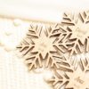 Detalle del grabado en Marcasitios de madera copo de nieve personalizados para boda