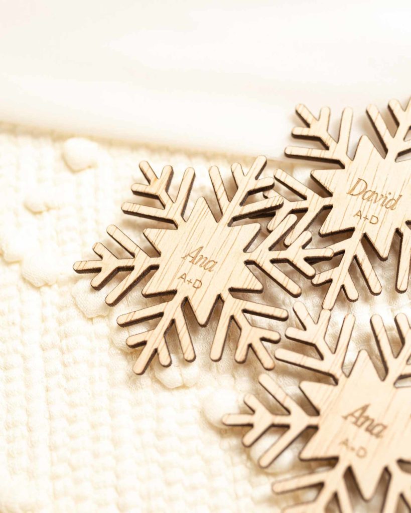Detalle del grabado en Marcasitios de madera copo de nieve personalizados para boda