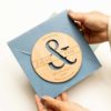 Sobre artesanal para boda con invitaciu00f3n Persu00e9 sostenido en la mano