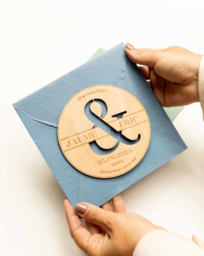 Sobre artesanal para boda con invitación Persé sostenido en la mano