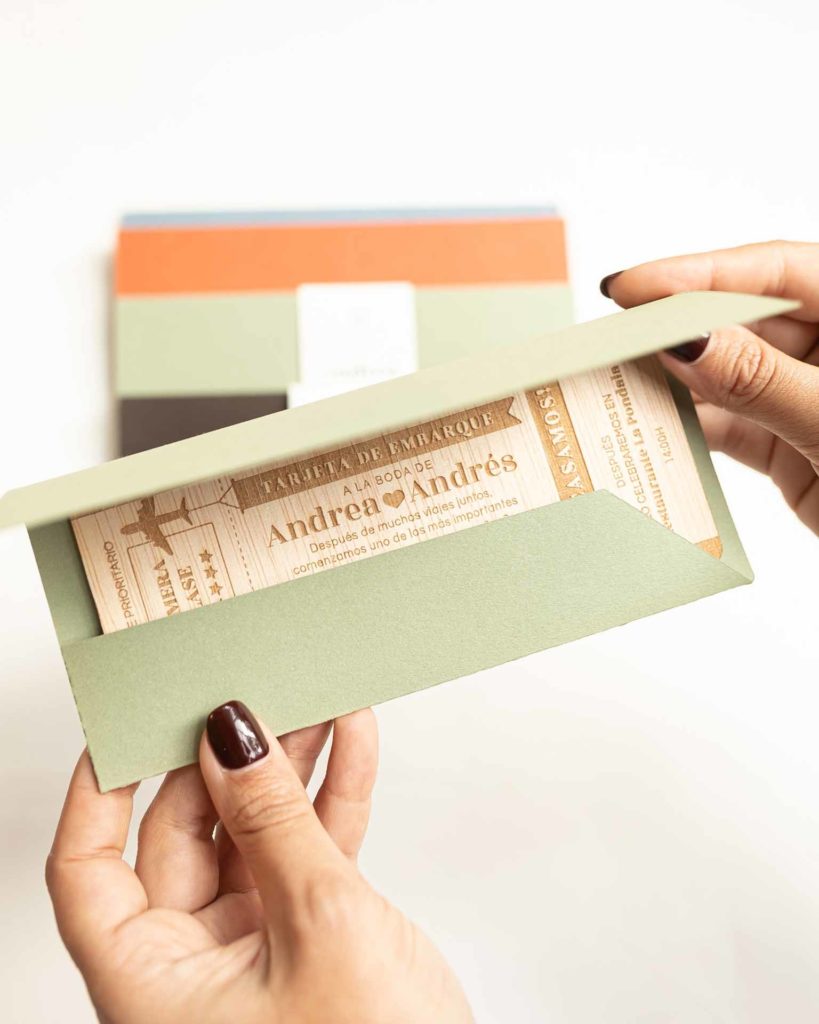 Sobre Aventura en mano junto con la invitación Aventura, mostrando la presentación completa de una boda elegante y personalizada.