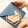Sobre clásico para boda con invitación Nida sostenido en la mano