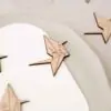 Marcasitio de madera con forma de grulla de papel origami y la inicial del invitado, colocado sobre un plato