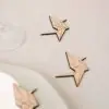 Marcasitios de madera Grulla Origami con iniciales grabadas, colocados sobre mantel en decoración de boda