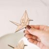 Tamau00f1o real del marcasitio Grulla Origami mostrado en la mano, con grabado personalizado en madera