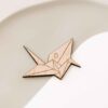 Detalle frontal del marcasitio Grulla Origami con su silueta de grulla de papel grabada en madera
