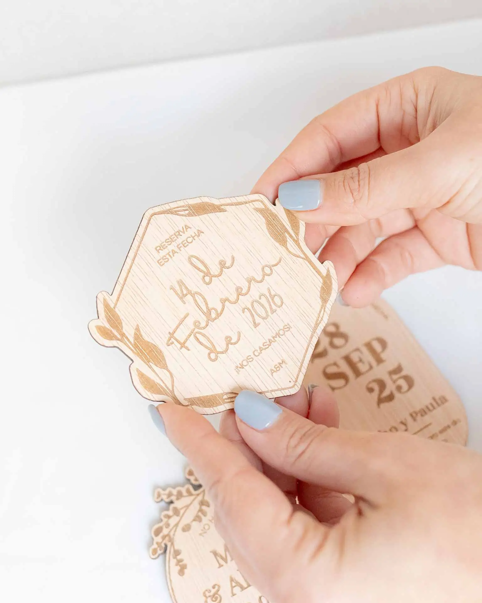 Tamaño y proporción del Save the Date personalizado en madera modelo 1 sujetado con la mano