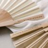 Abanicos personalizados disponibles en blanco roto y marru00f3n nude, con grabado en madera para eventos