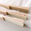Primer plano del grabado personalizado en el canto de madera del abanico, con mensaje o fecha de boda