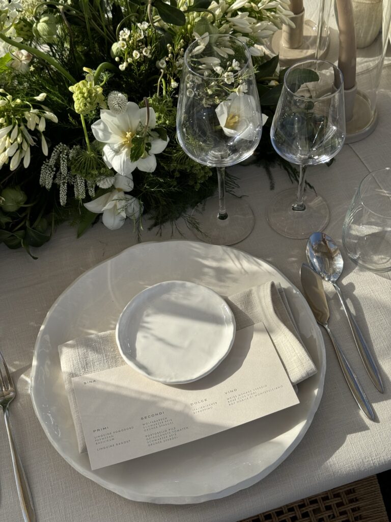 Vista de una mesa de boda rústica con cubiertos completos, servilleta de tela y detalles naturales en la decoración