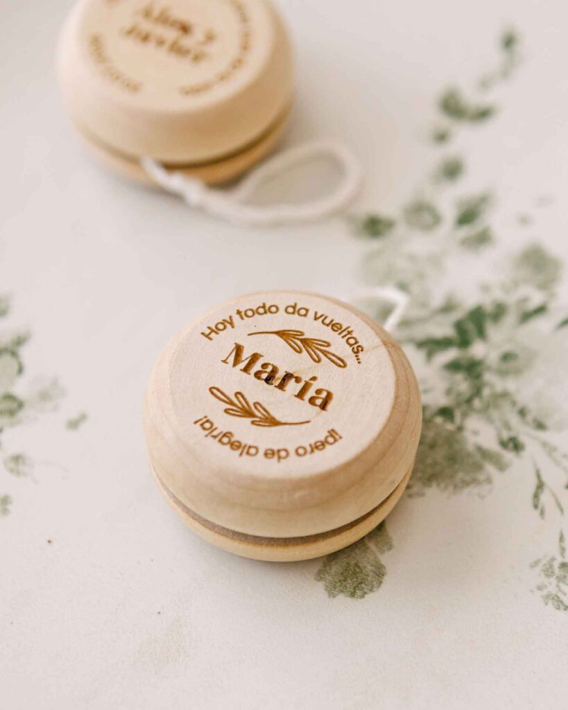 Conjunto de yoyos de madera personalizados con diferentes nombres y frases, ideales para eventos