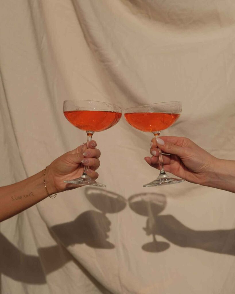 Dos manos brindando en una boda íntima con copas, símbolo de un momento especial y emotivo