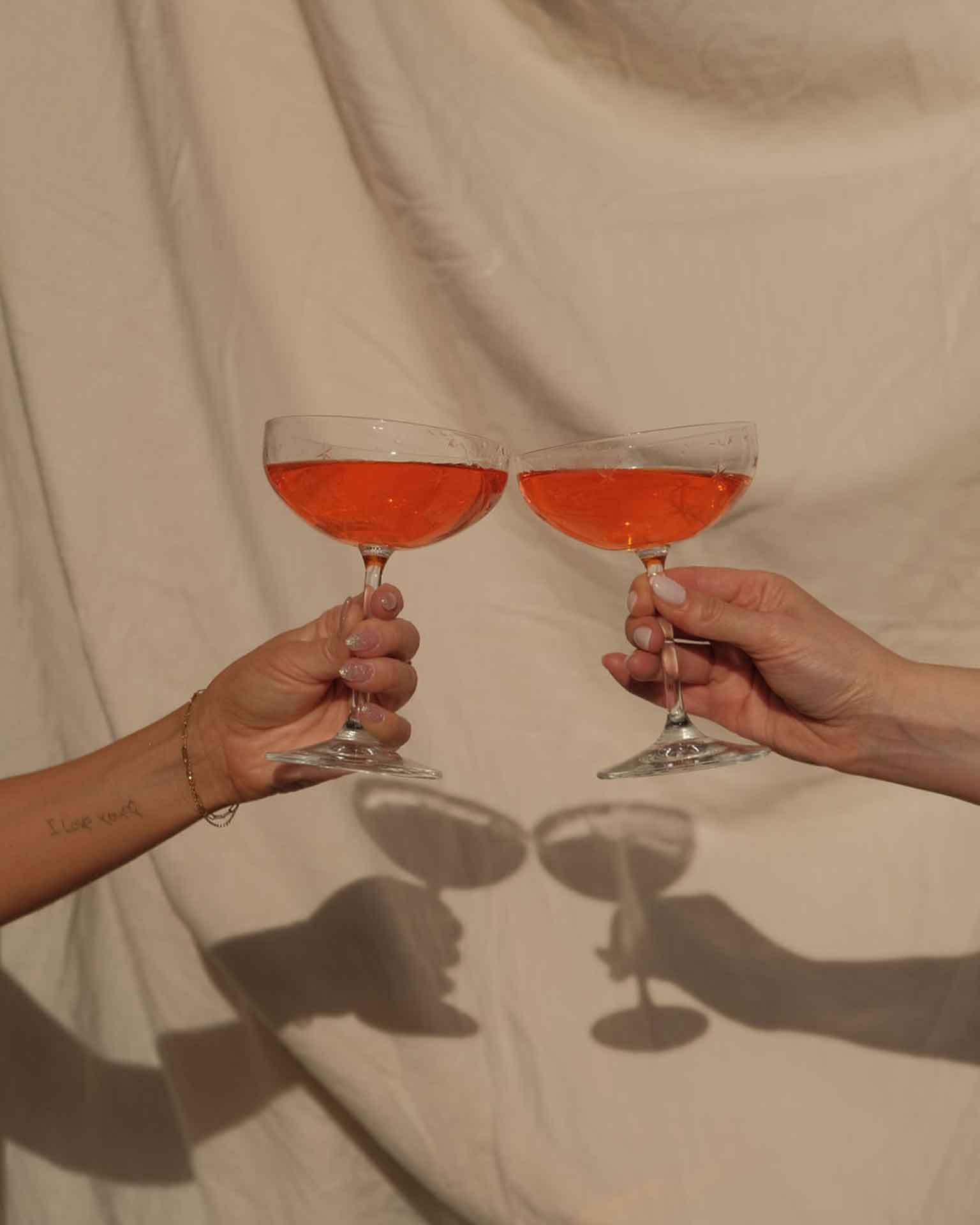Brindis en una boda íntima con detalles personalizados Dos manos brindando en una boda íntima con copas, símbolo de un momento especial y emotivo