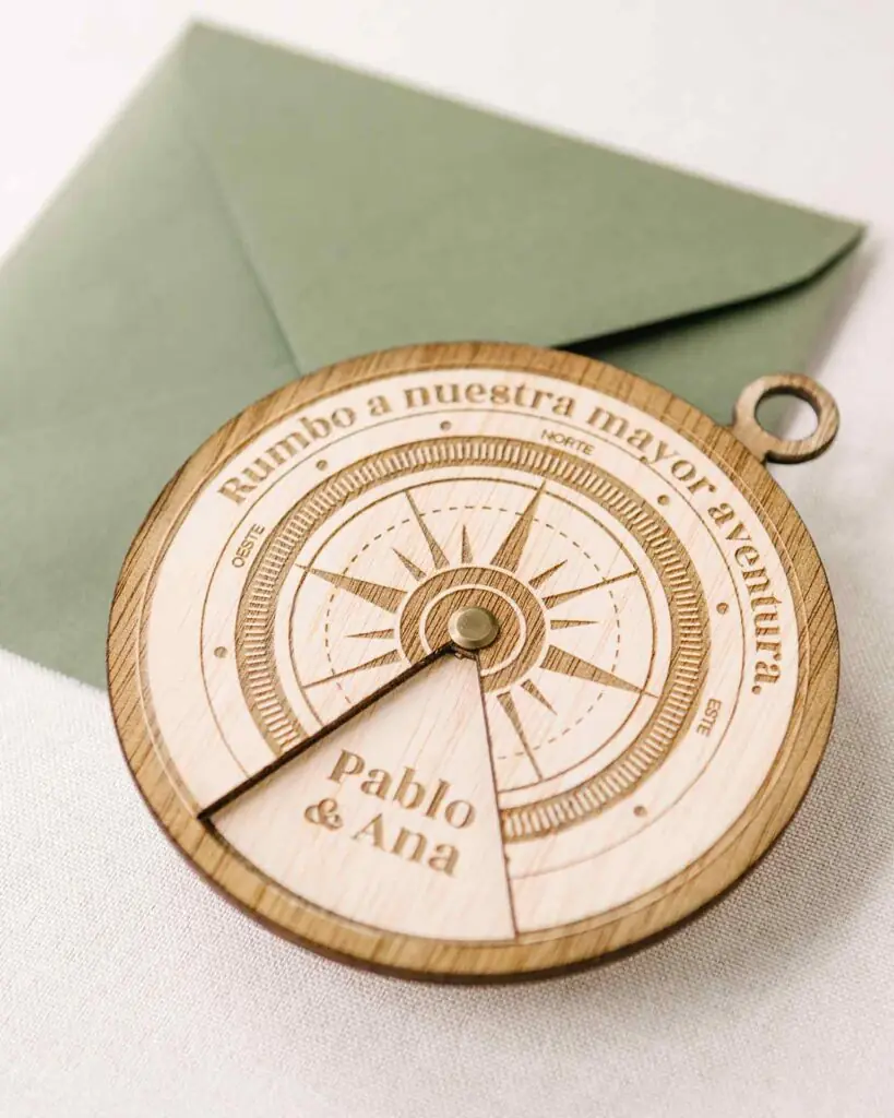 Invitación de boda de madera con forma de brújula giratoria, símbolo de camino compartido en bodas de 2026.