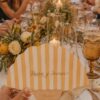 Abanico minuta personalizado a rayas sobre mesar real de boda