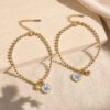 Dos pulseras No me olvides doradas con charms de flor azul y piezas imantadas para compartir.